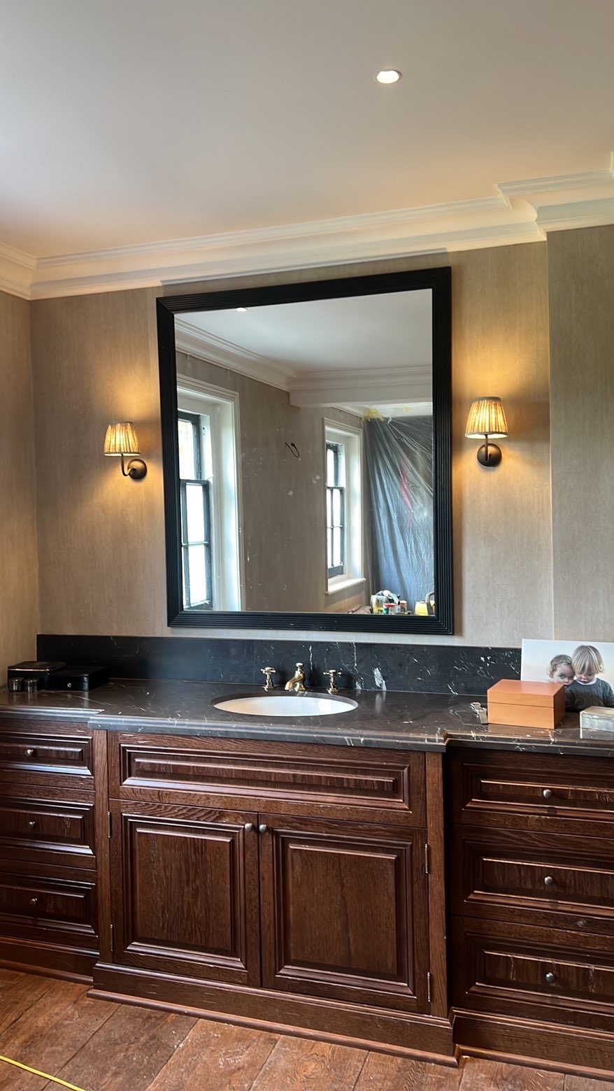 Two lit wall lights either side of a mirror above a bathroom vanity