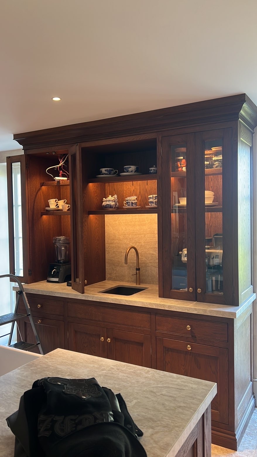 Dark oak dresser with lit glass cabinets and illuminated open shelving