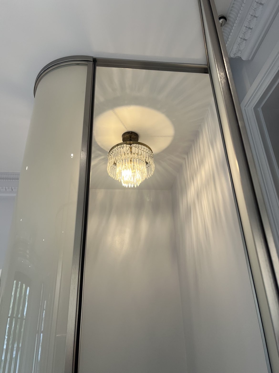 Crystal flush ceiling light fitted above a fitted wardrobe
