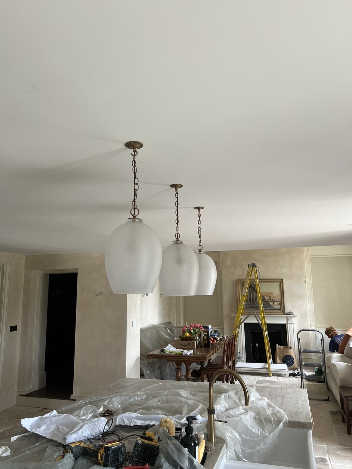 Three glass pendant lights hung in a row above a kitchen island