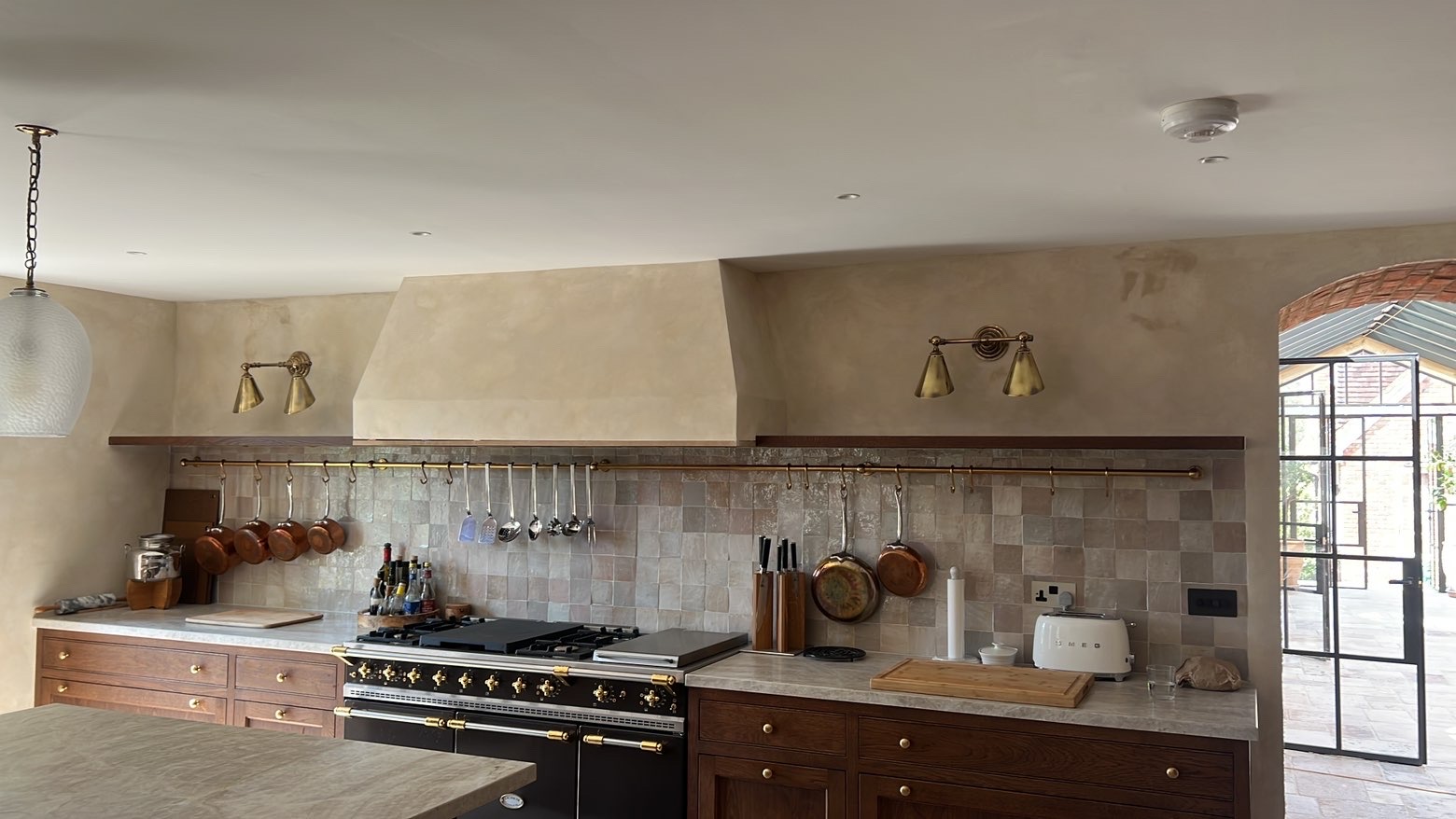 Kitchen with brass twin wall lights, recessed downlights and a glass pendant, installed by MA Electricals